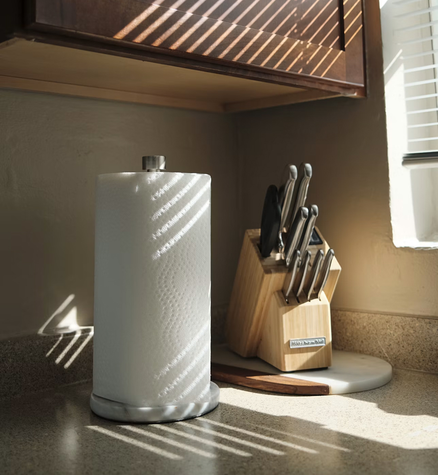 A roll of paper towels on a sunlit kitchen counter