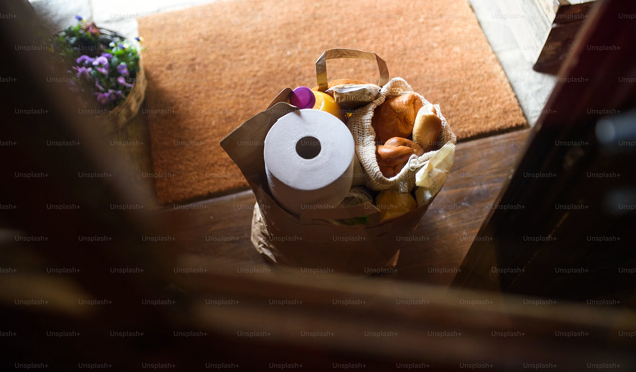 A paper bag of groceries on a wooden table
