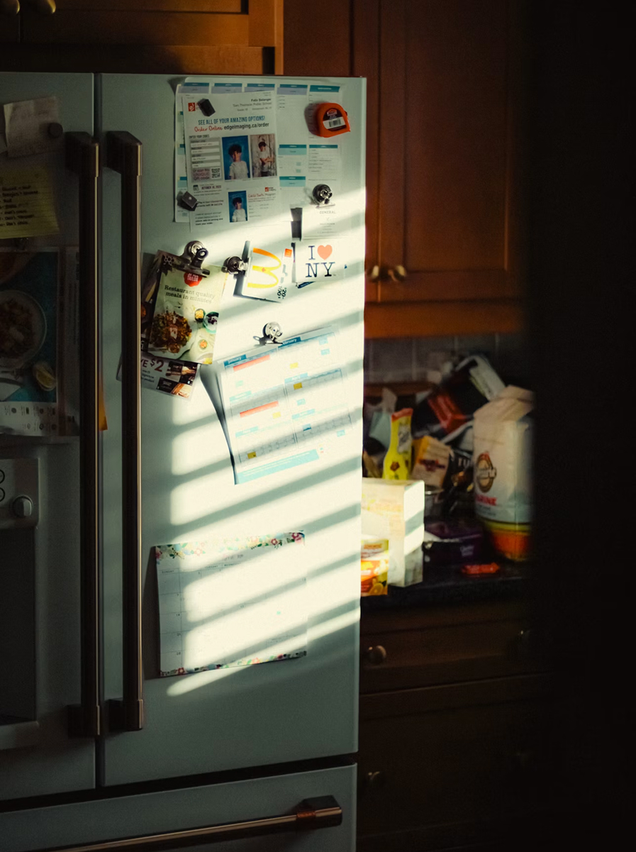 A fridge door covered in notes and magnets